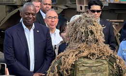 U.S. Defense Secretary Lloyd Austin talks with a ghillie-suited soldier of the Royal Australian Army’s 1 Brigade at HMAS Coonawarra, the country’s busiest naval base. Austin came to Darwin in Australia’s Northern Territory for a Nov. 17 trilateral meeting with his Australian and Japanese counterparts.