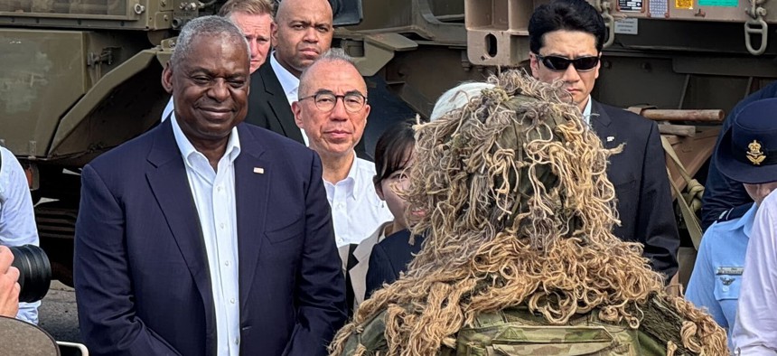 U.S. Defense Secretary Lloyd Austin talks with a ghillie-suited soldier of the Royal Australian Army’s 1 Brigade at HMAS Coonawarra, the country’s busiest naval base. Austin came to Darwin in Australia’s Northern Territory for a Nov. 17 trilateral meeting with his Australian and Japanese counterparts.