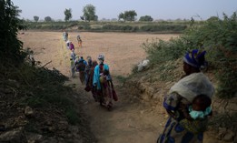 In this 2022 photo, women cross the dry bed of the White Volta river to their farms in Burkina Faso from northern Ghana.