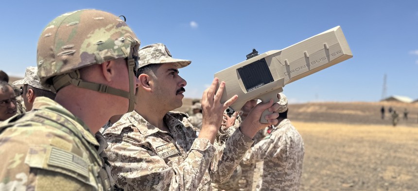 A U.S. soldier instructs a Jordanian Armed Forces service member on how to use a Dronebuster during a training exercise in Jordan, May 13, 2024. 