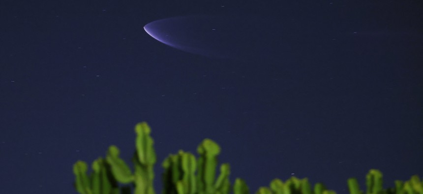 A SpaceX Falcon 9 rocket carrying 20 Starlink internet satellites soars into space after launching from Vandenberg Space Force Base on December 4, 2024, seen behind a cactus from San Diego, California.