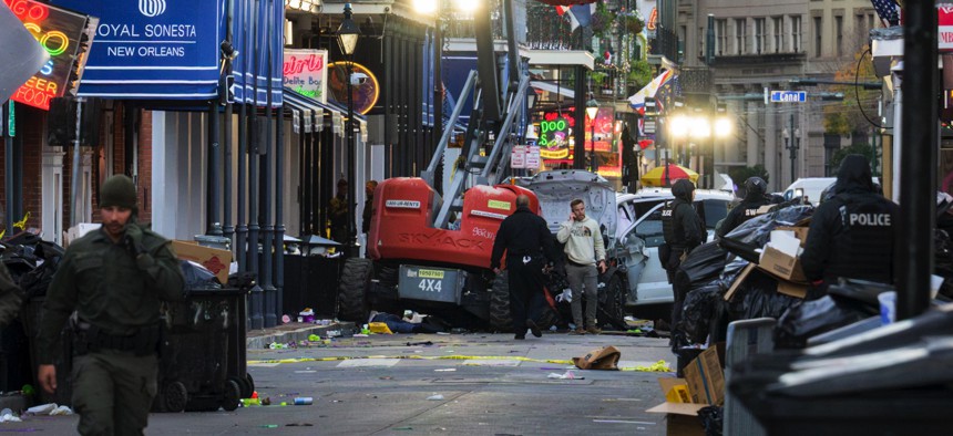 Police investigators surround the white Ford F-150 pickup truck that crashed into a work lift after allegedly driving into a crowd of New Year's revelers in the French Quarter of New Orleans, Louisiana, on January 1, 2025. 