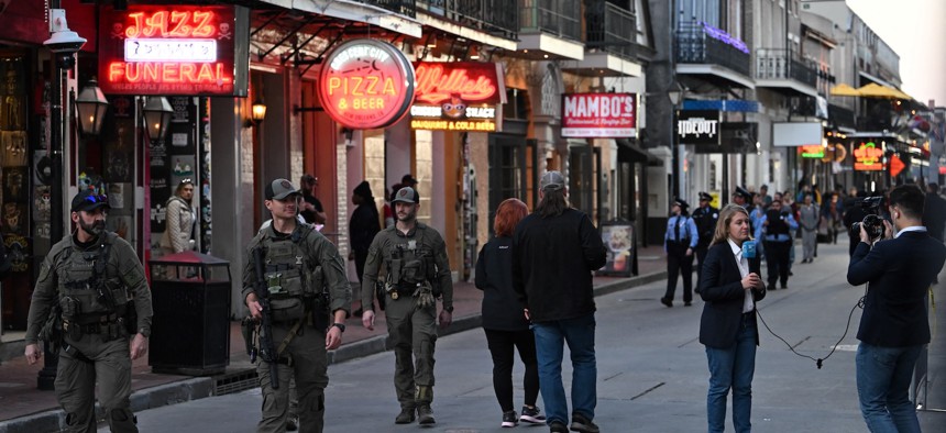 Police walking down Bourbon Street past reporters on January 2, 2025, in New Orleans, Louisiana, the day after an attack by a man driving a truck down Bourbon street in the French Quarter. 