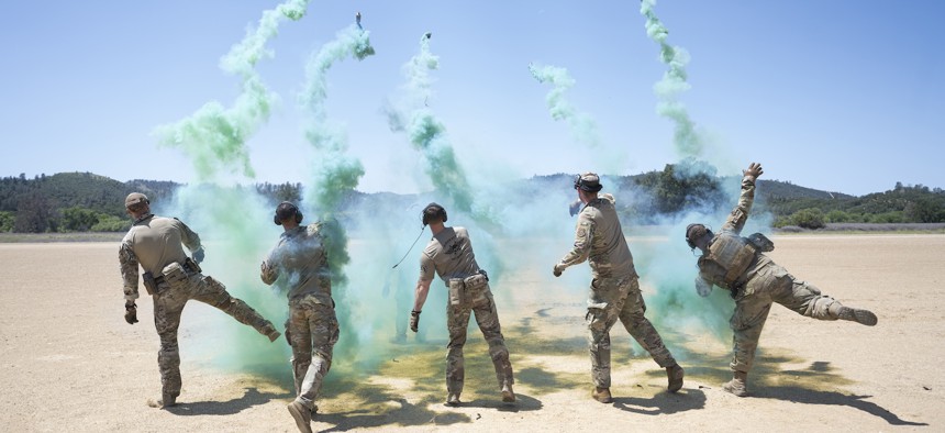 Airmen with the 821st Contingency Response Group pop smoke to assist a UH-60L Black Hawk helicopter landing during a base defense exercise at Fort Hunter-Liggett in Jolon, California, May 2, 2024.