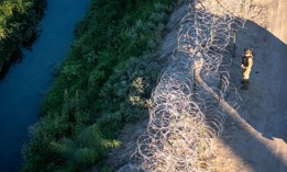 A Texas National Guard soldier inspects razor wire along the bank of the Rio Grande at the U.S.-Mexico border on September 18, 2024, in El Paso, Texas. 