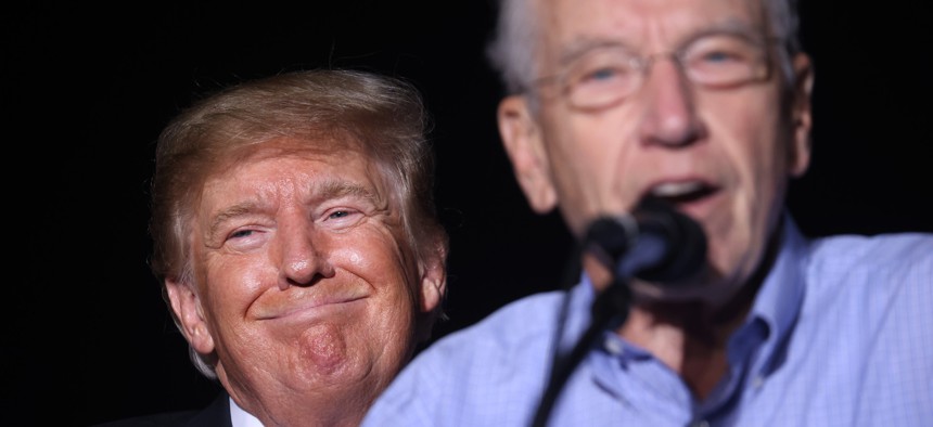 President Donald Trump smiles as Sen Chuck Grassley, R-Iowa, speaks during a rally at the Iowa State Fairgrounds on Oct. 9, 2021, in Des Moines, Iowa. Grassley previously said he "intends to defend" inspectors general. 