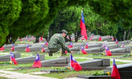 A Taiwanese soldier places flowers as a tribute to fallen soldiers at the Taiwushan Cemetery during a ceremony held to mark the 65th anniversary of the Second Taiwan Strait Crisis, in Kinmen on August 23, 2023. 