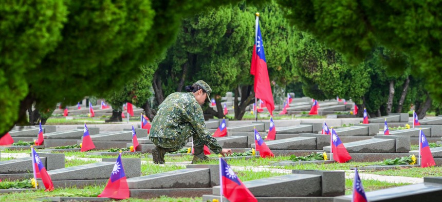 A Taiwanese soldier places flowers as a tribute to fallen soldiers at the Taiwushan Cemetery during a ceremony held to mark the 65th anniversary of the Second Taiwan Strait Crisis, in Kinmen on August 23, 2023.