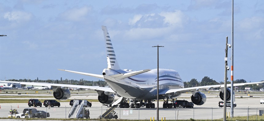 The motorcade of US President Donald Trump is parked next to an almost 13 year old Qatari Boeing 747 sitting on the tarmac of Palm Beach International airport on February 15, 2025.
