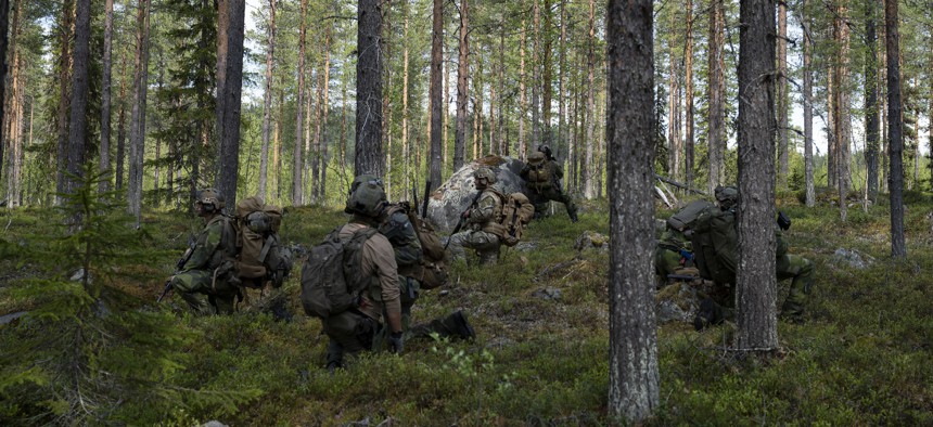 A U.S. Air Force airman and Swedish Air Force rangers move towards a simulated downed pilot during training at Kallax Air Base, Sweden, on June 5, 2025.