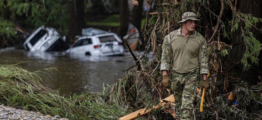 A search and rescue worker looks through debris for any survivors or remains of people swept up in the flash flooding on July 6, 2025, in Hunt, Texas.