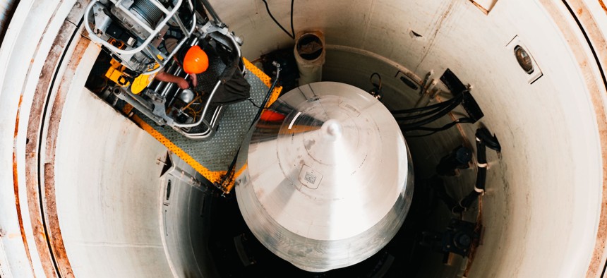 Airman 1st Class Aiden Williams climbs onto the maintenance platform to enter the launch tube during a guided missile maintenance platform installation at F.E. Warren Air Force Base, Wyoming, July 9, 2025. 
