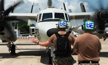 A sailor assigned to Air Test and Evaluation Squadron (VX) 1, signals during an operation check of an E-2D Hawkeye at Naval Air Station Patuxent, River, Md., July 11, 2025. 