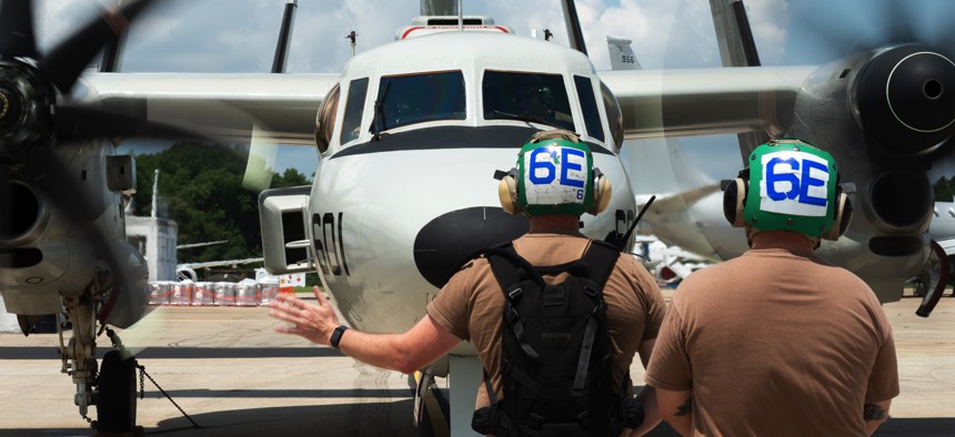 A sailor assigned to Air Test and Evaluation Squadron (VX) 1, signals during an operation check of an E-2D Hawkeye at Naval Air Station Patuxent, River, Md., July 11, 2025.