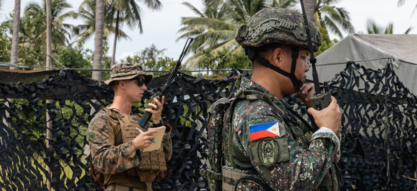 U.S. Marine Corps Capt. Holdon Loveless and a Philippine marine conduct fires deconfliction on radios during KAMANDAG 9 at Quezon, Philippines, June 4, 2025.
