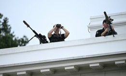 Members of the Secret Service's counter sniper team look out from the roof of the West Wing of the White House on Aug. 5, 2025.