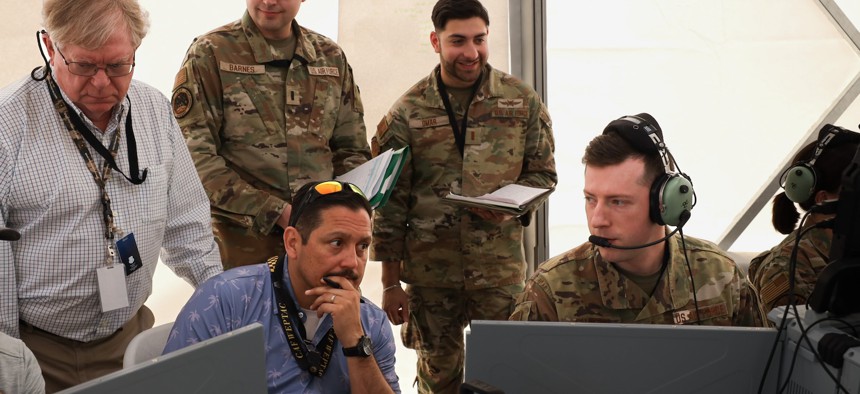 Tech. Sgt. Peyton Shaffer, right, a weapons director for 752nd Operations Support Squadron, discusses his observations of a mission thread on the Tactical Operation Center – Light with members of the Air Force Operational Test and Evaluation Center, the 605th Test and Evaluations Squadron, and the 46th Test Squadron during Project Convergence Capstone 5 at the National Training Center, Fort Irwin, California, March 10, 2025.
