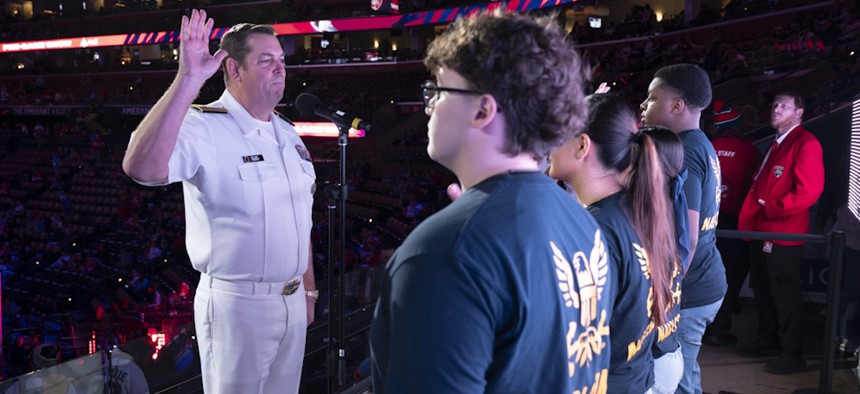Navy Chief of Information Rear Adm. Ryan Perry administers the oath of enlistment for four future sailors during the Florida Panthers game against the Los Angeles Kings, Jan. 29, 2025. 