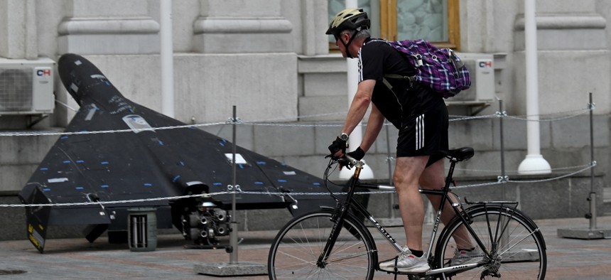 A man rides a bicycle past a Shahed-136 drone displayed outside the Ukrainian Ministry of Foreign Affairs in Kyiv on July 21, 2025, amid the Russian invasion of Ukraine.