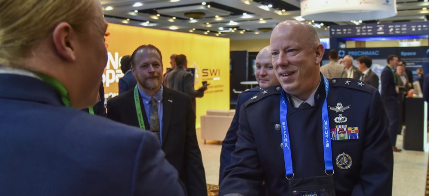Maj. Gen. Stephen Purdy, military deputy, acting assistant secretary of the Air Force and service acquisition executive for space, shakes hands with Staff Sgt. Alisa Boyle of the Air Force Research Laboratory during the Space Symposium in Colorado Springs, Colo., April 8, 2025.