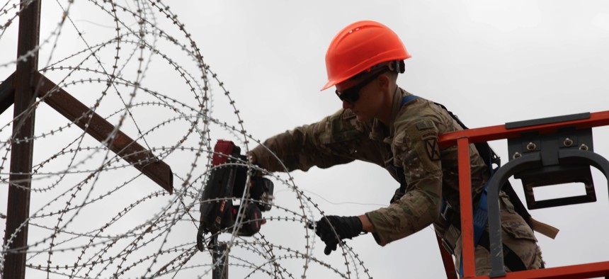 A soldier of the 41st Engineer Battalion, assigned to Joint Task Force-Southern Border, reinforces a protective barrier with concertina wire near El Paso, Texas, July 17, 2025.