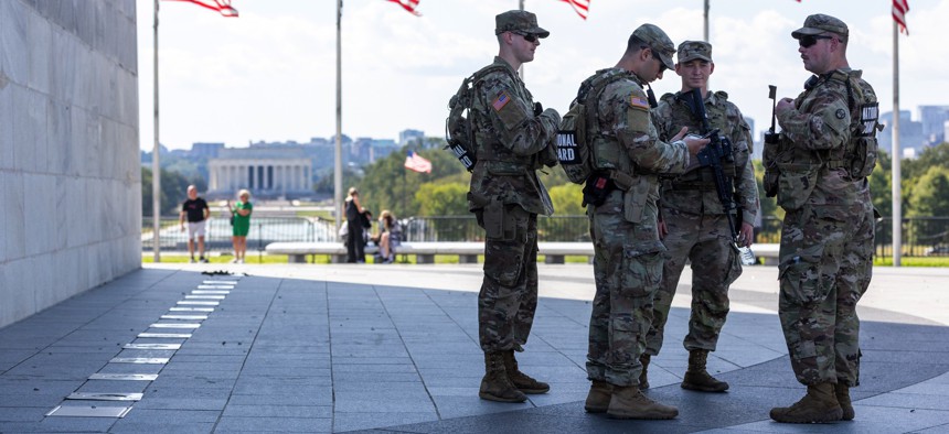 Members of the National Guard patrol the National Mall and seek shade on a hot September day in Washington, D.C., on September 3, 2025. 