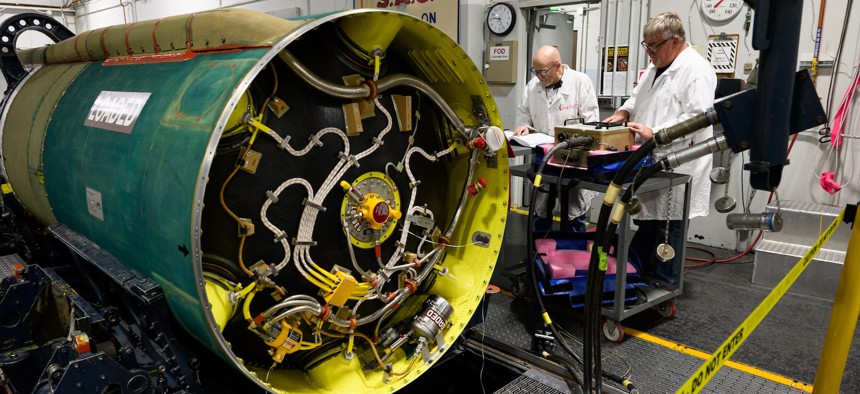 Kent Gallegos and Dean Overturf, 582nd Missile Maintenance Squadron special weapons system mechanics, perform maintenance on a Minuteman III booster at Hill Air Force Base, Utah, June 2, 2025.