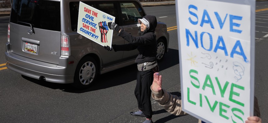 Demonstrators protest against DOGE cuts as they wade into traffic along Maryland Route 410 outside the headquarters of the National Oceanic and Atmospheric Administration on March 3, 2025 in Silver Spring, Md.The Trump administration fired about 800 probationary staff at NOAA in late February.