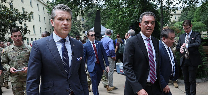 Defense Secretary Pete Hegseth, left, walks with Emil Michael, Defense Undersecretary for Research & Engineering, while touring an exhibit of autonomous systems at the Pentagon July 16, 2025.
