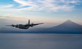 A U.S. Air Force C-130H3 Hercules aircraft, including a 94th Airlift Wing tail insignia that dates to World War II, flies away from Mount Fuji, Japan, after airdrop operations on July 28, 2025.