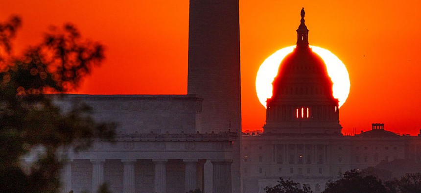 The sun rises behind the U.S. Capitol with the Lincoln Memorial, left, and Washington Monument, center, in Washington, DC, as seen from the Netherlands Carillon on September 19, 2025, in Arlington, VA. 