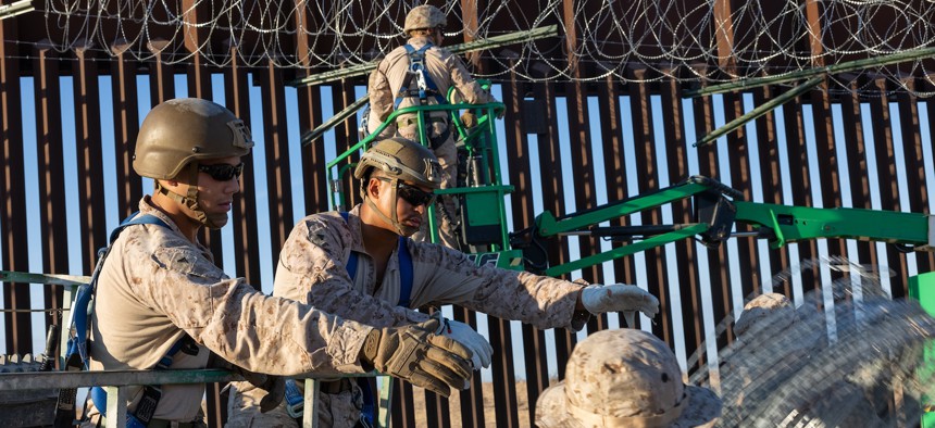 U.S. Marines place concertina wire using a 460SJ telescopic boom lift to reinforce the southern border barrier in Yuma, Ariz., Oct. 9, 2025. 