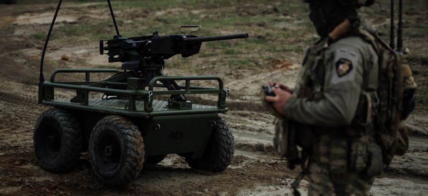 A Ukrainian soldier of the 214th Separate Assault Battalion controls a Rys Pro unmanned ground vehicle armed with a remote-controlled machine-gun during training on April 18, 2025.