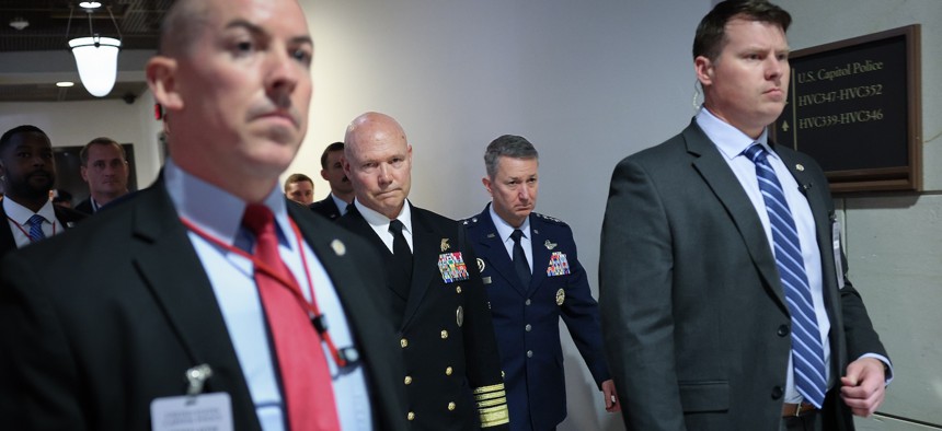 Adm. Frank Bradley (2nd L), escorted by Chairman of the Joint Chiefs of Staff Gen. Dan Caine (2nd R), departs a closed door classified meeting with lawmakers on Capitol Hill on December 4, 2025. 