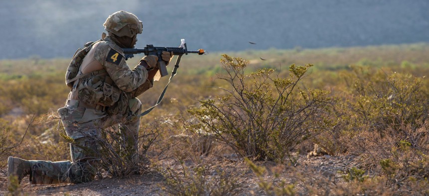 A soldier representing Joint Readiness Training Center, Fort Polk, Louisiana, returns fire with his M4 carbine during the 2025 FORSCOM Best Squad Competition, on Fort Bliss, Texas, Aug. 14, 2025