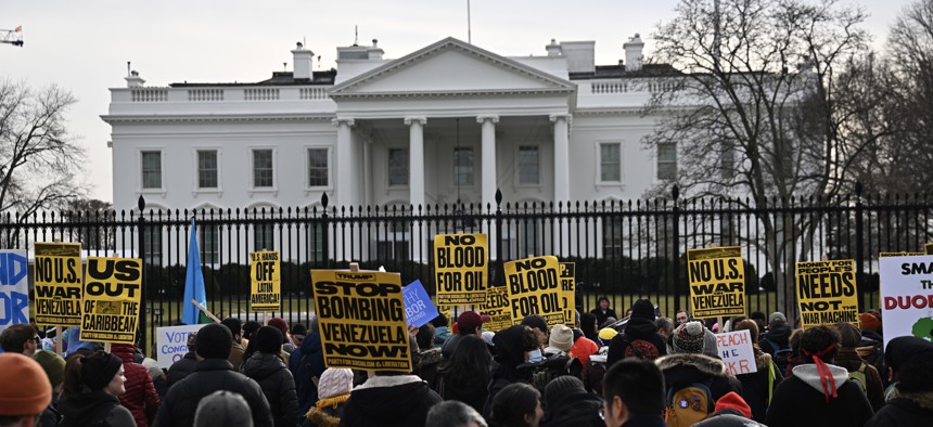 People carrying banners gather to protest the U.S. attacks on Venezuela, in Washington, D.C., on January 3, 2026.