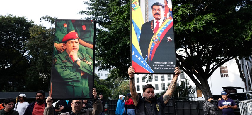 Supporters of Nicolas Maduro and late Hugo Chavez hold posters with their images after explosions and low-flying aircraft were heard on January 03, 2026 in Caracas, Venezuela. 