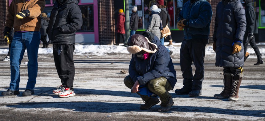 A person kneels near the site where 37-year-old Alex Pretti was allegedly shot and killed by federal agents on Jan. 24, 2026, in Minneapolis, Minnesota. Federal agents allegedly shot and killed Pretti, a south Minneapolis resident, amid a scuffle to arrest him. 