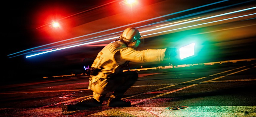 A sailor signals the launch of an F/A-18E Super Hornet aircraft from the flight deck of the USS Gerald R. Ford while underway in the Caribbean Sea, Jan. 19, 2026.