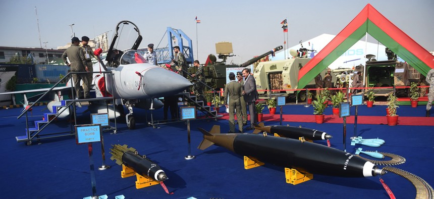 Military officials gather around Pakistan's JF-17 Thunder aircraft and other ammunition during International Defence Exhibition and Seminar (IDEAS) 2022 at the Expo Centre in Karachi on November 16, 2022.