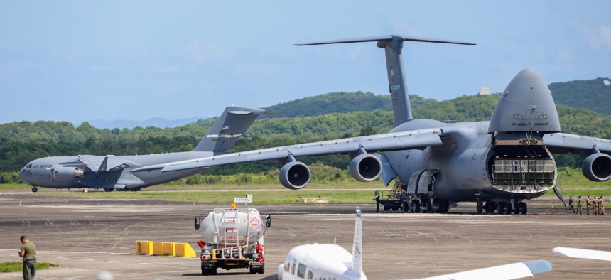 A C-17 arrives at the Jose Aponte de la Torre Airport in Puerto Rico while a C-5 unloads, Sept. 12, 2025.