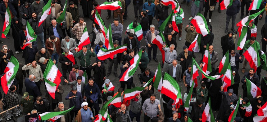 Protesters gather with Iranian national flags during a demonstration in support of the government and against US and Israeli strikes outside a mosque in Tehran on February 28, 2026.