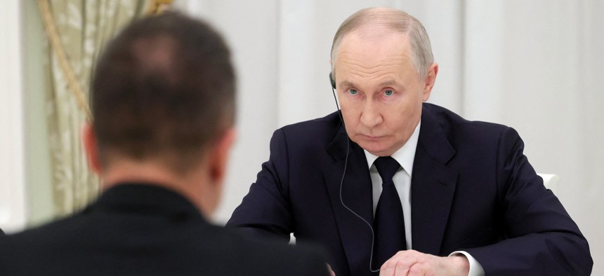 In this pool photograph distributed by the Russian state agency Sputnik, Russia's President Vladimir Putin (R) meets Hungarian Foreign Minister Peter Szijjarto in Moscow on March 4, 2026.