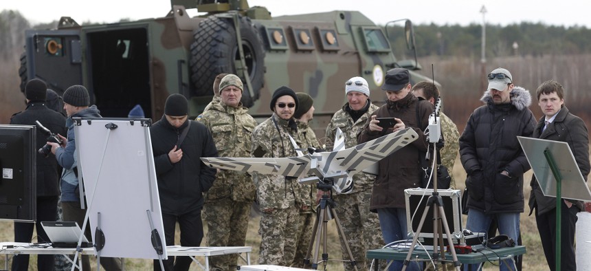 Serviceman of Ukrainian National Guard stand next to the latest ukrainian models of weapons and military equipment,during inspection of Ukrainian president PETRO POROSHENKO (not seen) in training base of National Guard in Novi Petrivtsi, outside Kiev,Ukraine,on April 04, 2015.