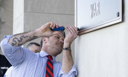 Defense Secretary Pete Hegseth finishes the installation of a "Department of War" plaque at the River Entrance in front of the Pentagon on Nov. 13, 2025