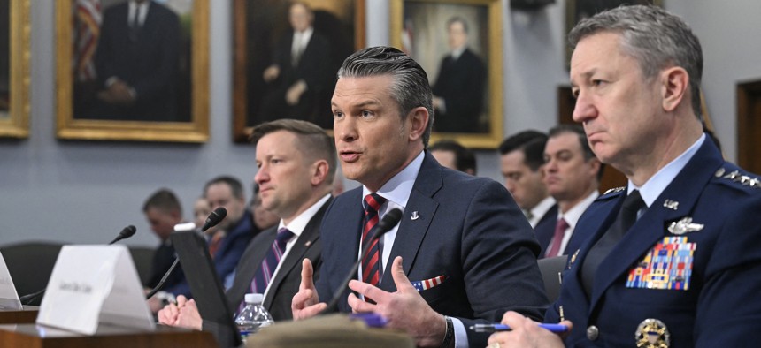 Defense Secretary Pete Hegseth speaks as Joint Chiefs Chairman Gen. Dan Caine waits to testify during a House Appropriations Committee panel hearing on the proposed 2027 defense budget in Washington, D.C., on May 12, 2026. 