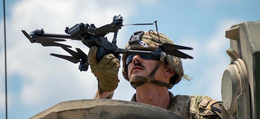 A soldier of the 2nd Armored Brigade Combat Team, 1st Cavalry Division, prepares to launch a drone during a 2025 exercise.
