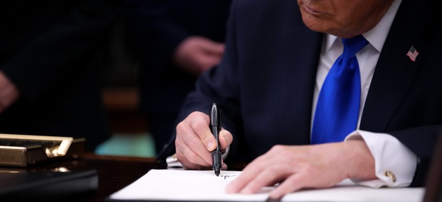 Donald Trump signs an executive order on April 30, 2026.