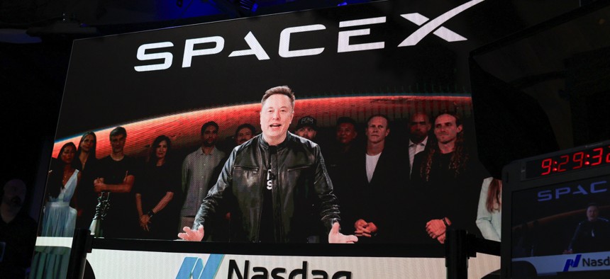SpaceX CEO Elon Musk, displayed on a screen remotely from SpaceX headquarters in Starbase, Texas, speaks before the launch of SpaceX's initial public offering (IPO) at the Nasdaq MarketSite in New York on June 12, 2026.