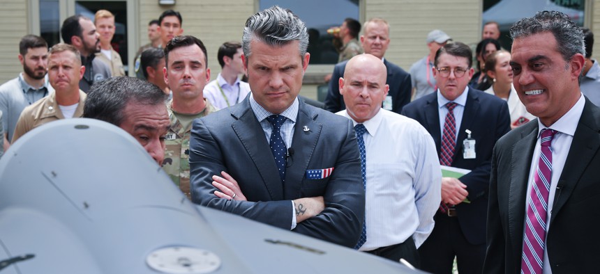 U.S. Secretary of Defense Pete Hegseth (L) is briefed on an exhibit of Multi-Domain Autonomous systems by Alexander Lovett (L), Deputy Assistant Secretary of Defense Prototyping and Experimentation and Emil Michael (R), Under Secretary of Defense (Research & Engineering, at the Pentagon July 16, 2025 in Arlington, Virginia. Michael just announced a new "War Force" initiative. 